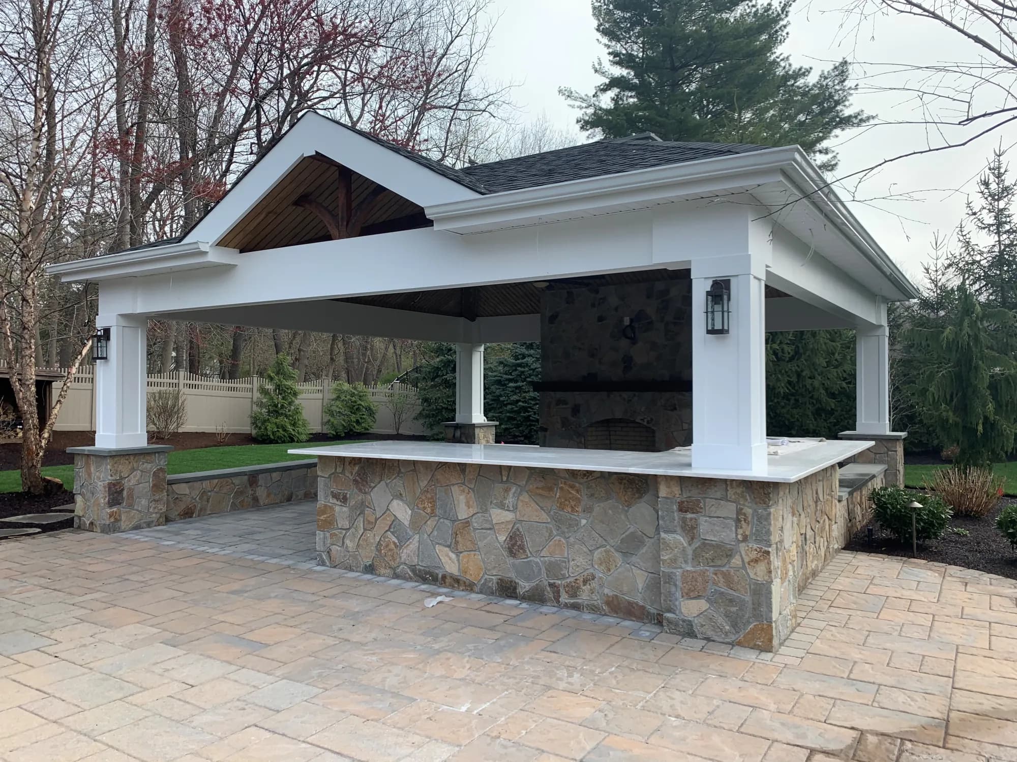 Covered pavilion with a stone bar, counter, and fireplace